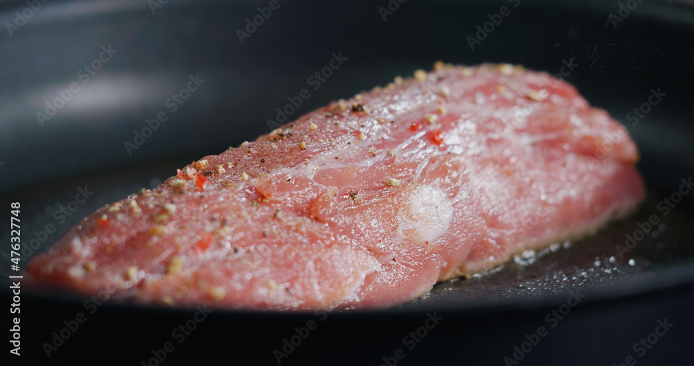Close Up Raw Pork Meat Seasoned is Frying in Hot Pan. Close Up Raw Pork Meat Seasoned is Frying in Hot Pan.