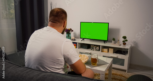 Man watches Green Screen Chroma Key Screen. Watching Tv at home interior. Watching a sport match. © RecCameraStock