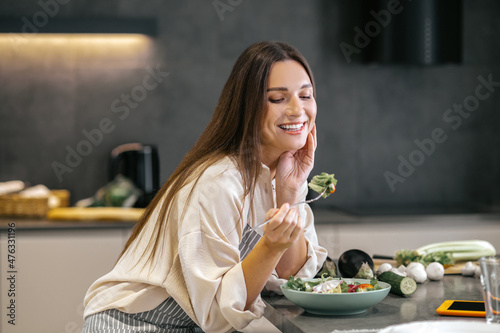 Fotografia Smiling happy woman eating with appetite