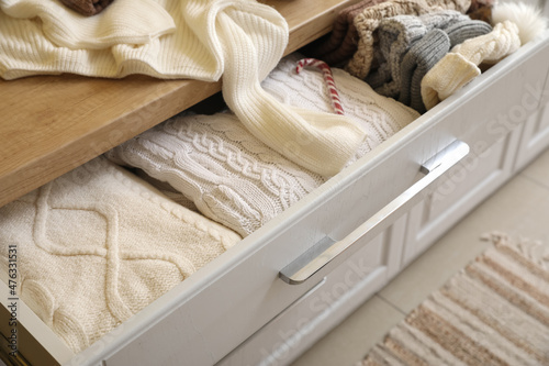 Folded winter clothes in chest of drawers