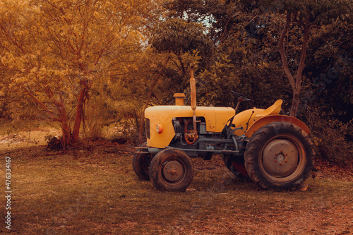 Old tractor in a rural setting in an antique-looking photo