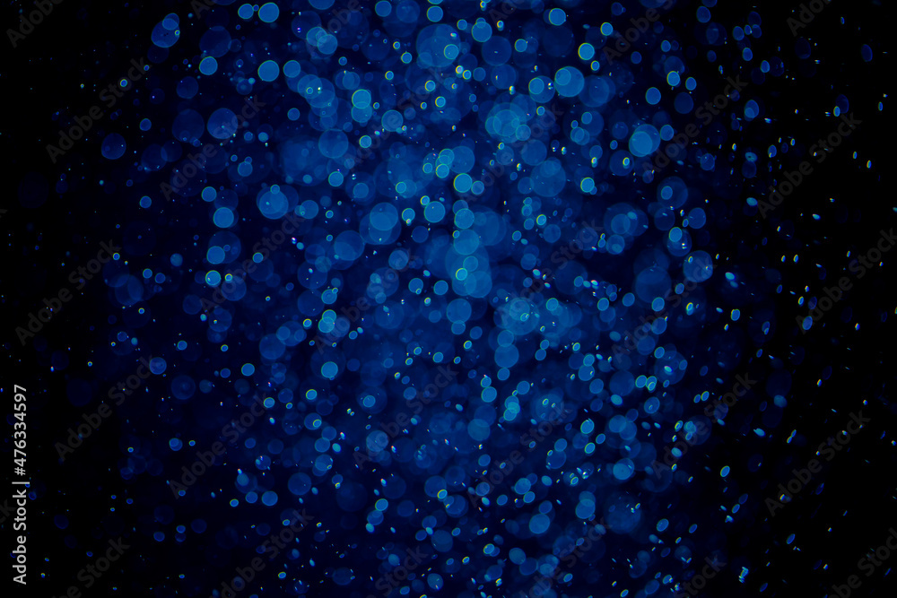 Glittering stars of blue bokeh with black background
