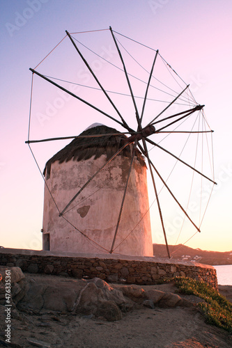 Windmill at the Greek island of Mykonos. Beautiful sunset color infused onto the rustic windmill.