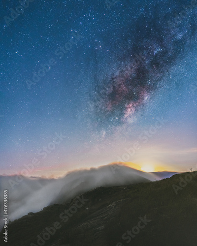 Milky way and the full moon rise in the mountains