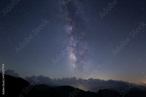 山並みを覆う雲の上に輝く星々と天の川 © Seiichi Fukui