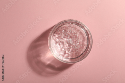 Jar of cosmetic gel on pink background  top view