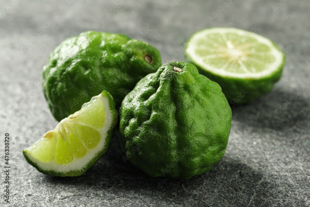Whole and cut ripe bergamot fruits on grey table Whole and cut ripe bergamot fruits on grey table