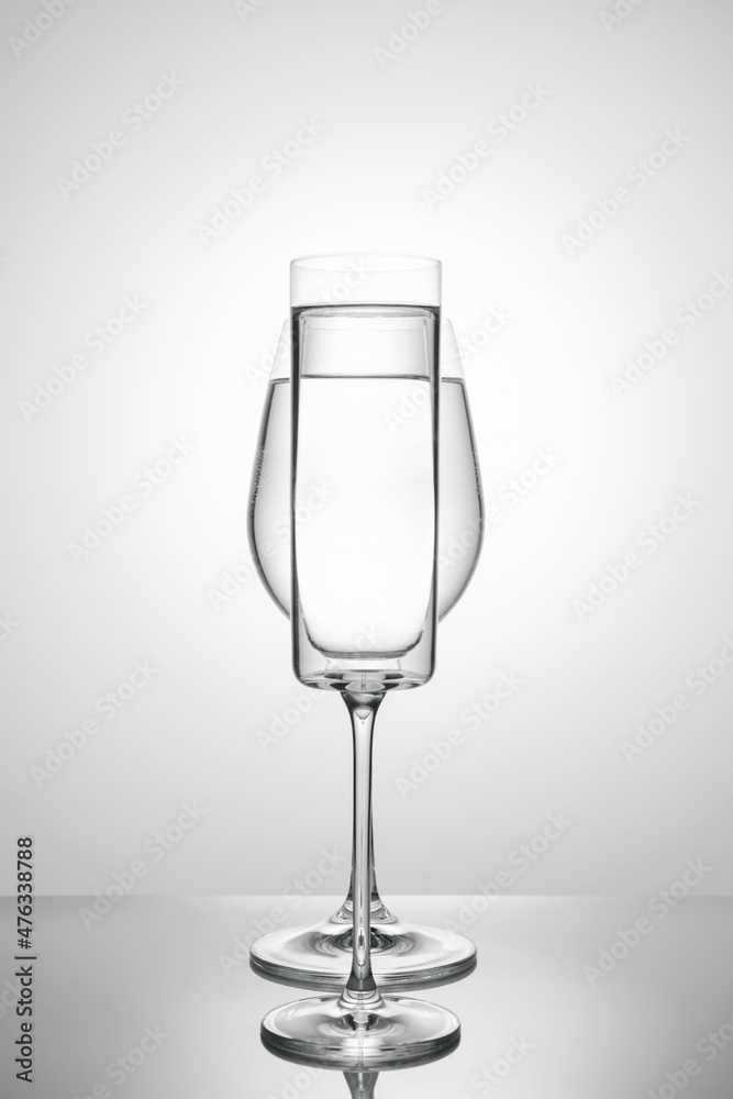Fototapeta premium Two glasses of different shapes on a white background.