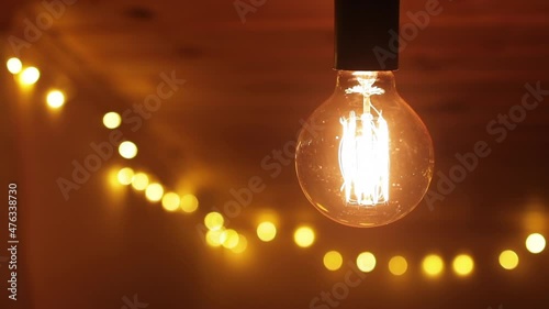 Retro light bulb flickering on a wooden ceiling, close up