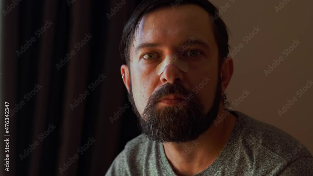 Close-up of sad man with a bandage on the nose looking directly in the camera, Domestic violence, family problems, Stress, violence, being a Victim Close-up of sad man with a bandage on the nose looking directly in the camera, Domestic violence, family problems, Stress, violence, being a Victim