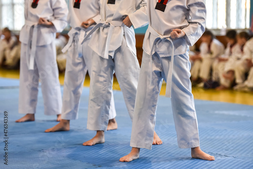 Taekwondo kids. Boys athletes stand in a taekwondo uniform with a white belts during a taekwondo tournament