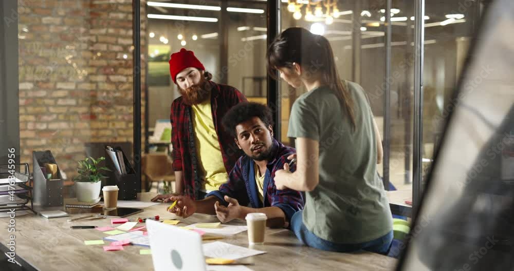 Creative millennial developers brainstorming in loft office. Diverse ...