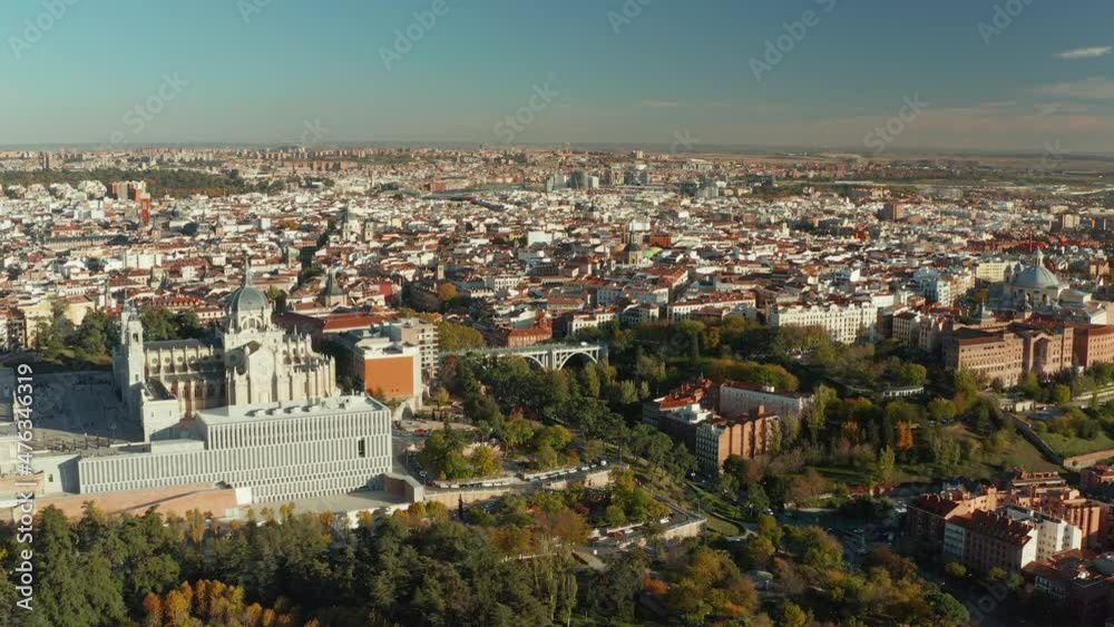 Forwards fly above town park. Aerial view of large city with historic landmarks. Almudena Cathedral above valley spanned by Segovia Viaduct. Forwards fly above town park. Aerial view of large city with historic landmarks. Almudena Cathedral above valley spanned by Segovia Viaduct.