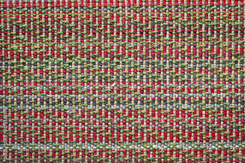 Seamless texture of warm woolen multicolored rug pattern wallpaper background. Green, red, gray, blue and white color thread.