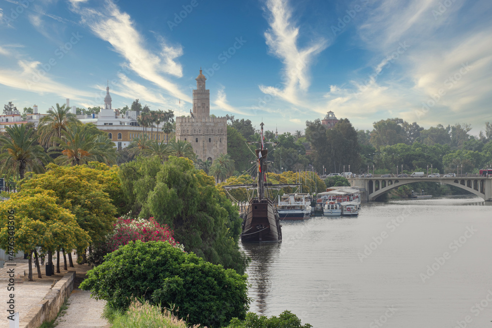 Fototapeta premium Vista de la Torreo del Oro en Sevilla, con una carabela atracada en su proximidad, tomada desde el puente de Triana