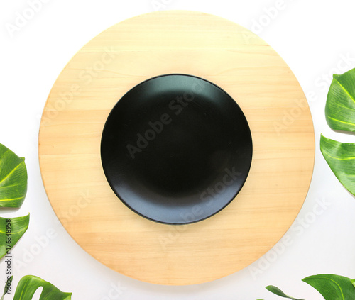 dish is placed on a round wooden table with monstera palm leaves for decoration photo