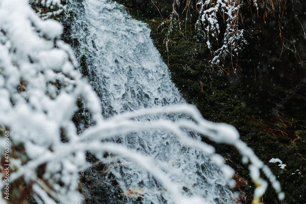 Naklejka premium View of the Jana Waterfall during the snowfall at Manali, Himachal Pradesh, India. Waterfall during the winter snow in Manali, Holiday background, Travel Concept. Snowfall in Manali during the winter.