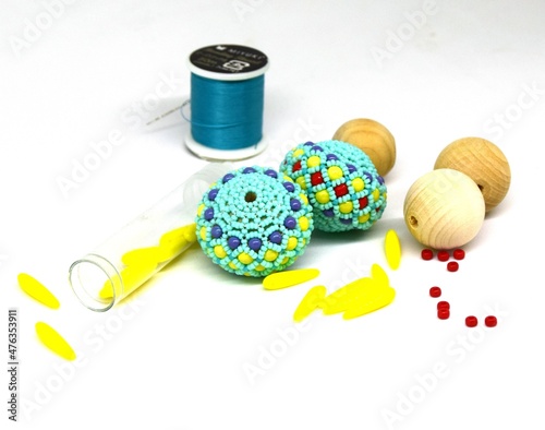 A mixture of threads and beads of different shapes and sizes on a white background
