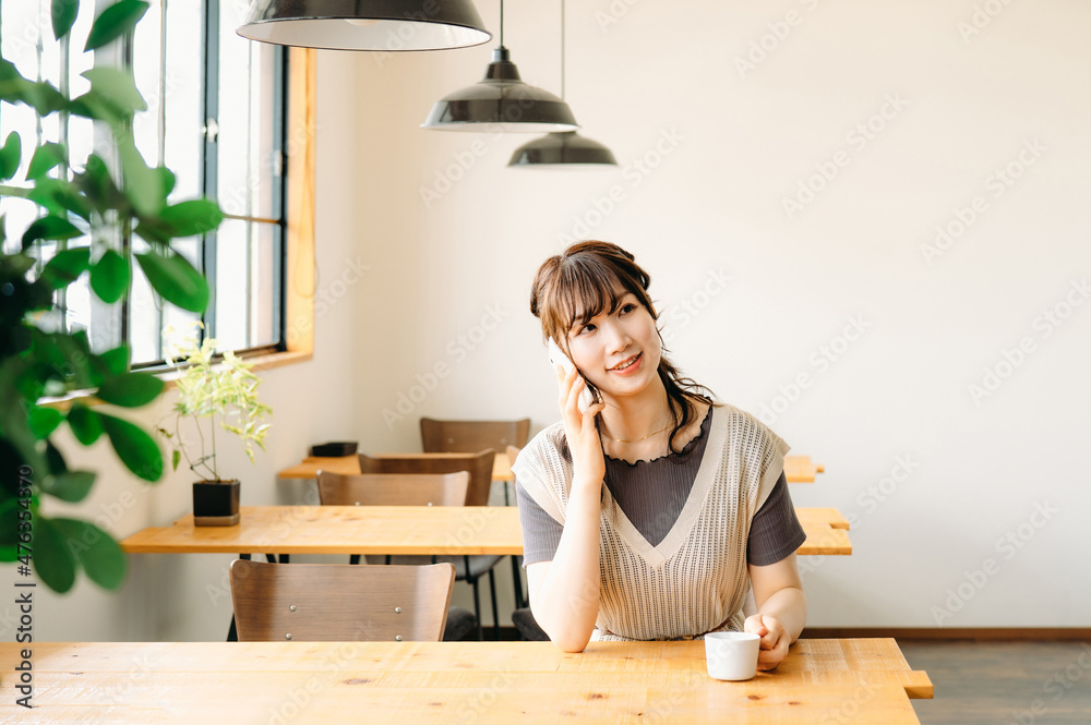 カフェでスマホを使う女性(電話)
カフェでスマホを使う女性(電話)