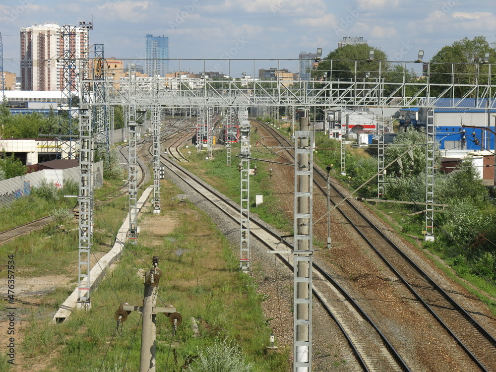Fototapeta premium suburban railway tracks with poles and rails in summer