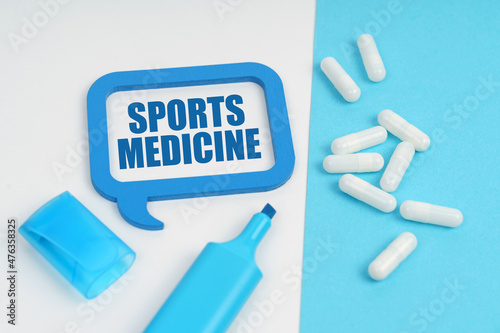 On the white and blue surface are a marker, tablets and a plate inside which the inscription - Sports Medicine