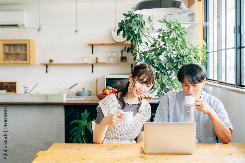 家でパソコンを使う男女
