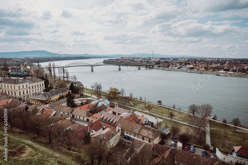 A panoramic view of the Mária Valéria Bridge spanning the Danube River, connecting the cities of Esztergom, Hungary, and Párkány (Štúrovo), Slovakia. The image captures the bridge, the river, and the 