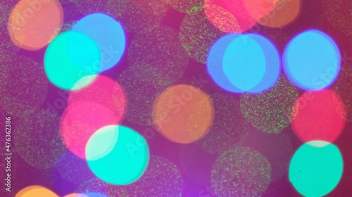 Christmas mood, round defocused lights. Beautiful festive screensaver. Merry christmas congratulation. Abstract background of glowing garlands at night in the dark.