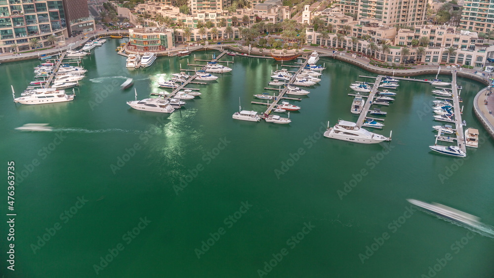 Luxury boats and yachts docked in Dubai Marina aerial timelapse.