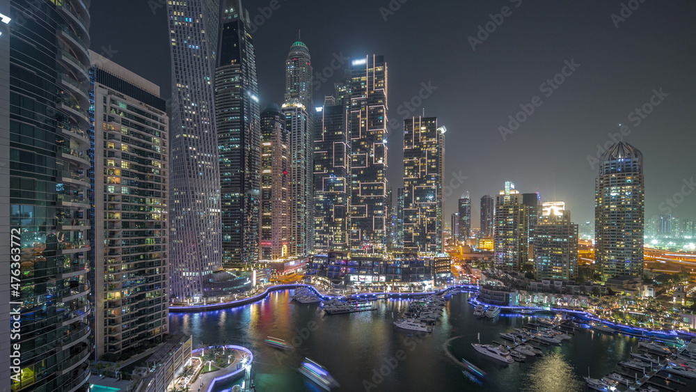 Fototapeta premium Dubai marina tallest skyscrapers and yachts in harbor aerial night timelapse.