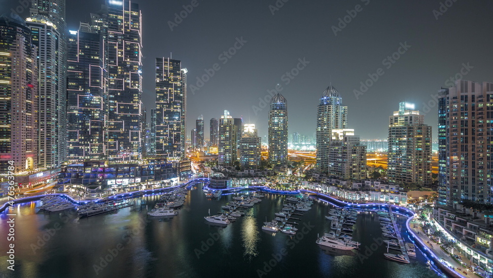 Luxury yacht bay in the city aerial night timelapse in Dubai marina