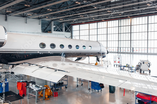 Fotografie Maintenance of airplane in large white hangar