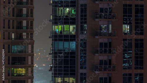 Flat night panorama of multicolor light in windows of multistory buildings aerial timelapse.