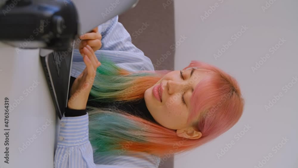 Freelance photographer communicating with client. Stock video of young creative girl with dyed hair typing a message on laptop computer