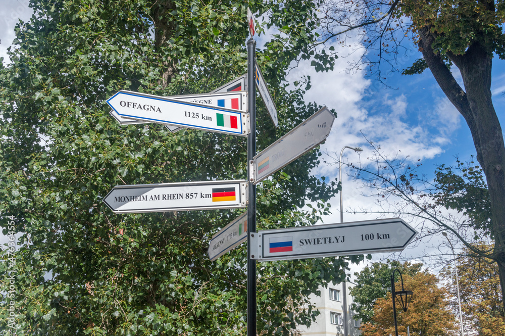 Obraz premium Twin towns fingerpost signage in Malbork. Distances in kilometers in the Malbork city in Poland showing distances to others cities.