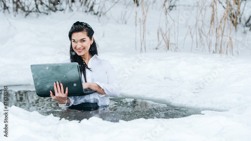 Tableau sur toile Girl with laptop in frozen lake ice hole