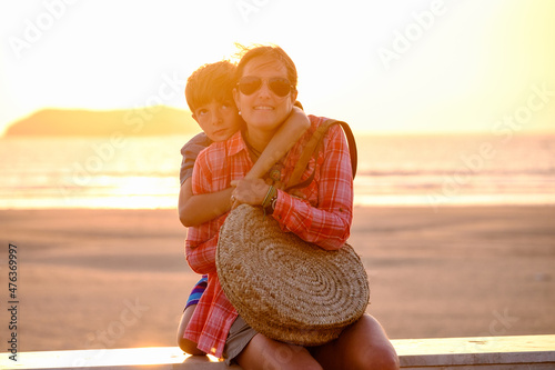 Mother and son at sunset with the sea in the background Fotobehang