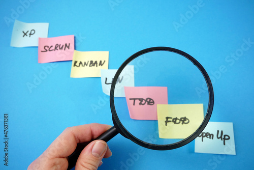 magnifying glass and software scrum agile board with paper task, TDD (test-driven development) and FDD (Feature driven development) photo