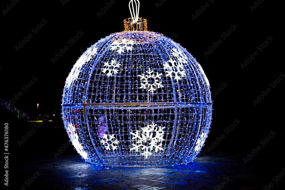 Obraz premium Large Christmas ball on the street in the light of night lights