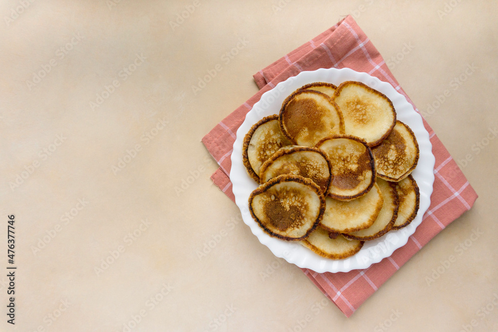 Fried pancakes on beige background, space for text