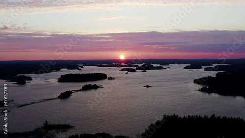 Aerial drone sliding left over stunning lake scenery with many islands by colorful sunset. photo