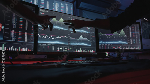 Two professional male economists looking at stock charts on monitors doing AltCoin analysis