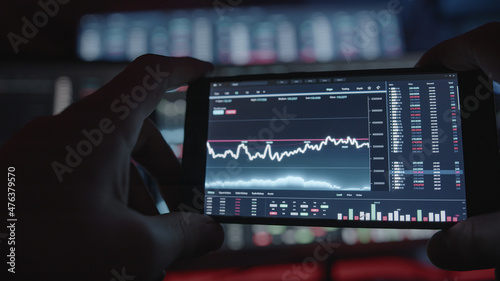 Young person daily trading on crypto stock app interface on mobile smartphone