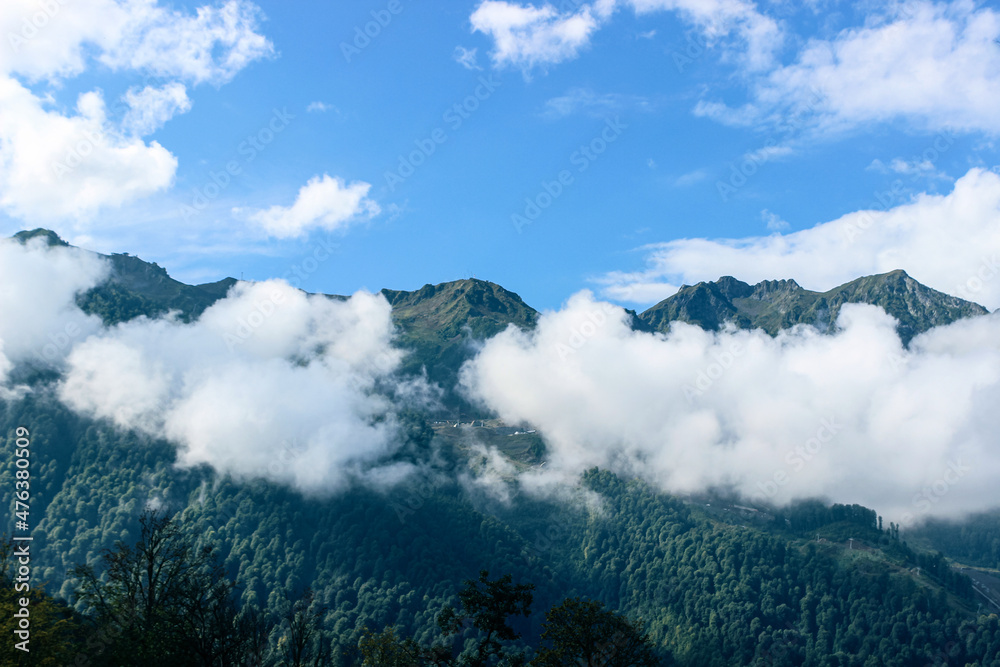 Thick white clouds float in the mountains. Beautiful mountain landscape. Nature background Thick white clouds float in the mountains. Beautiful mountain landscape. Nature background