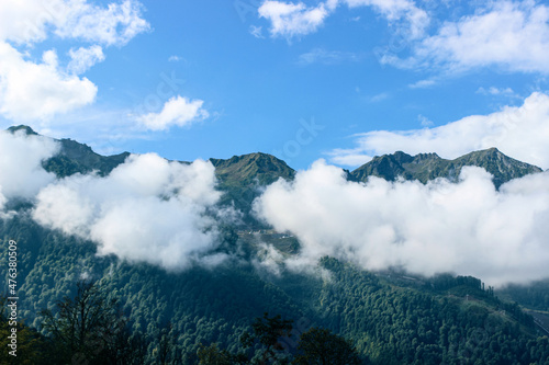 Thick white clouds float in the mountains. Beautiful mountain landscape. Nature background  © Mariya Fedorova