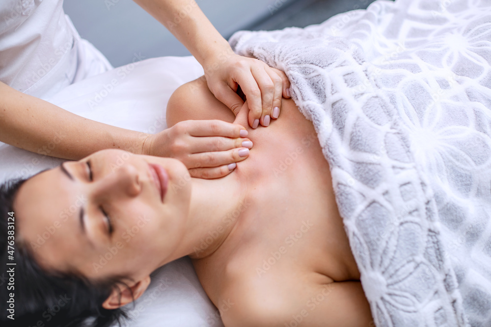 Body massage for a young woman. Alternative health methods with aromatic oils. Cosmetology procedures for face and body skin. Skin care in adulthood. Horizontal photo of people. Body massage for a young woman. Alternative health methods with aromatic oils. Cosmetology procedures for face and body skin. Skin care in adulthood. Horizontal photo of people.