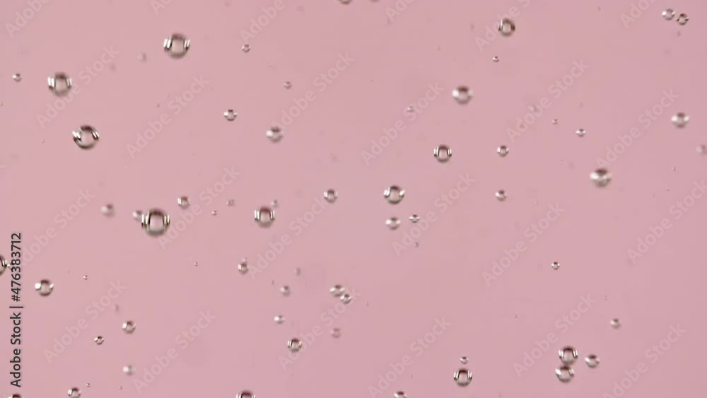 Macro shot of air bubbles in water rising up on light pink background. Slow motion. High quality FullHD footage Macro shot of air bubbles in water rising up on light pink background. Slow motion. High quality FullHD footage