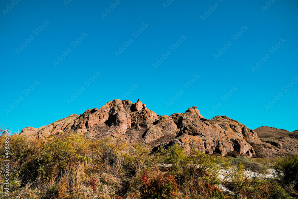A beautiful view of the red rocky mountain on the contrasting blue sky background.