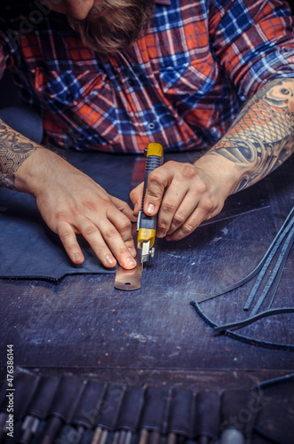 Artisan cutting out leather goods photo