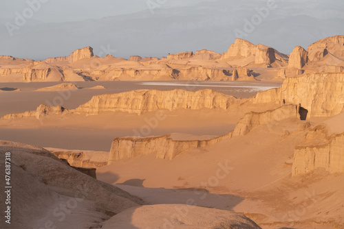 Cloudy, warm morning in the bizzare landscape of Lut desert, the hottest place on earth. Bizzare geological shapes rise from sand and dirt. Kerman Province, Iran. photo